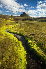 a small stream winds its way towards the peak of Storasula in Iceland