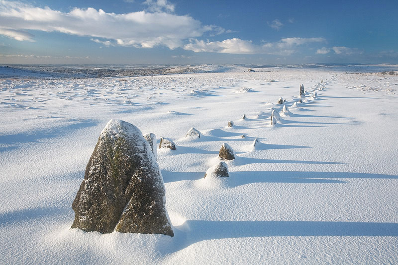 the main stone row of merrivale in freshly fallen snow with blue skies