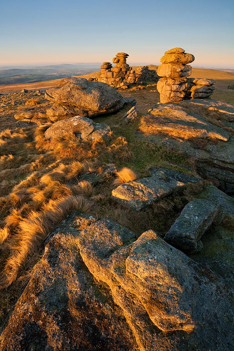 Golden light at sunrise on Staple Tor with a clear blue sky and excellent visibility