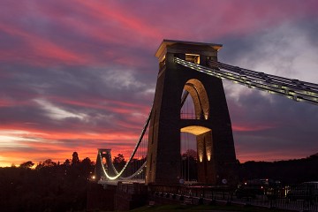 A view of Clifton Suspension Bridge at sunset with pink cirrus clouds above