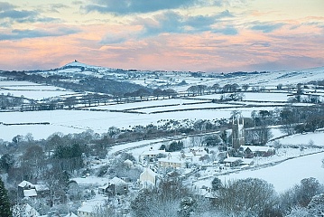 snow covering peter tavy and the surrounding area at sunrise