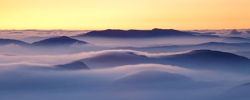view from glyder ridge of temperature inversion over snodonian hills at sunrise